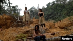 Indigenous people from the Mura tribe show a deforested area in unmarked indigenous lands, inside the Amazon rainforest, on August 20, 2019.