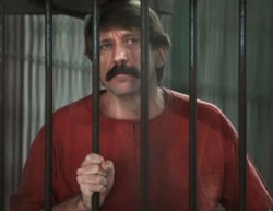 Russian arms trader Viktor Bout stands inside a cell at the criminal court in Bangkok, October 4, 2010.