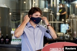 Canada's Prime Minister Justin Trudeau removes his face mask as he visits the Big Rig Brewery in Kanata, Ontario, Canada June 26, 2020. REUTERS/Patrick Doyle/File Photo
