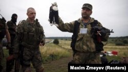 Ukraine -- A pro-Russian separatist holds a stuffed toy found at the crash site of Malaysia Airlines flight MH17, near the settlement of Hrabovo in the Donetsk region, July 18, 2014