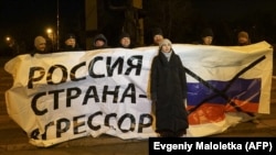 UKRAINE – Ukrainian protesters hold a banner reading ""Russia is an aggressor country" during a rally in Mariupol, on the south coast of the Azov Sea, eastern Ukraine, on November 28, 2018.