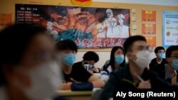 Students wearing face masks are seen inside a classroom during a government-organised media tour at a high school as more students returned to campus following the coronavirus disease (COVID-19) outbreak, in Shanghai, China May 7, 2020.