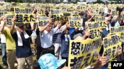 Japan -- Demonstrators hold placards that read "our fury has gone beyond the limit" during a rally against the US military presence in Naha, Okinawa prefecture, June 19, 2016