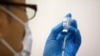 A staff member prepares the Moderna COVID-19 vaccine to be administered at a mass vaccination center in Tokyo, Japan, on May 24, 2021. (Carl Court/Reuters)