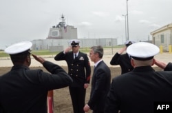 NATO Secretary General Jens Stoltenberg (C) reviews an honor guard during an inauguration ceremony of the U.S. Aegis Ashore Missile Defense Facility in Deveselu, Romania, May 12, 2016.