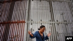 Mexico -- A worshiper participates in a Mass along the U.S.-Mexico border wall on February 22, 2015