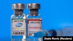 FILE PHOTO: Vials with Pfizer-BioNTech and Moderna coronavirus disease (COVID-19) vaccine labels are seen in this illustration picture taken March 19, 2021