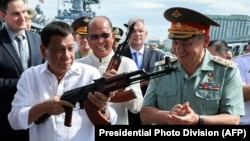 Philippine President Rodrigo Duterte (L) inspects Kalashnikov assault rifles with Russian Defense Minister Sergei Shoigu during the handover ceremony at the Port of Manila, October 25, 2017. (Robinson Ninal/AFP)