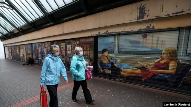 Women wearing face masks walk in the city center, amid the spread of the coronavirus disease (COVID-19), in Middleborough, Britain October 2, 2020