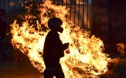 BOLIVIA - A man walks in front a fire blockade set by supporters of Bolivian ex-President Evo Morales in the outskirts of Sacaba, Chapare province, Cochabamba, on November 18, 2019