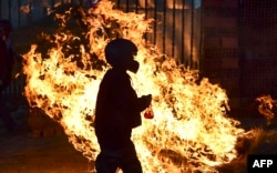 BOLIVIA - A man walks in front a fire blockade set by supporters of Bolivian ex-President Evo Morales in the outskirts of Sacaba, Chapare province, Cochabamba, on November 18, 2019