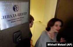 RUSSIA -- Levada Center employees leave their office with the sign " Levada-center. Jury Levada analytic center." in Moscow, May 20, 2013