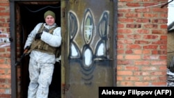 A Ukrainian serviceman stands on the doorstep of a house in Mariinka, on the front line with Russian-backed forces, Donetsk region, on February 7, 2022.