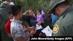 U.S. Border Patrol agents ask a group of Central American asylum seekers to remove hair bands and weddding rings before taking them into custody on June 12, 2018.