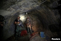 Afghanistan -- Afghan Special Forces inspect inside a cave which was used by suspected Islamic State militants at the site where a MOAB, or ''mother of all bombs'', struck the Achin district of the eastern province of Nangarhar, April 24, 2017