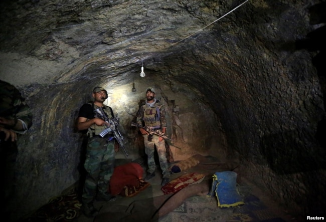 Afghanistan -- Afghan Special Forces inspect inside a cave which was used by suspected Islamic State militants at the site where a MOAB, or ''mother of all bombs'', struck the Achin district of the eastern province of Nangarhar, April 24, 2017