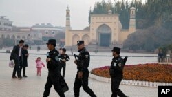 Uighur security personnel patrol near the Id Kah Mosque in Kashgar in western China's Xinjiang region on November 4, 2017.(AP Photo/Ng Han Guan, File)