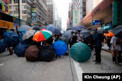 CHINA -- Protesters set up defense shield using umbrellas on a road in Mongkok, Hong Kong, Wednesday, May 27, 2020. Hong Kong Protests