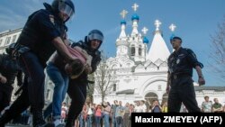 RUSSIA -- Russian police officers detain a protester during an unauthorized anti-Putin rally called by opposition leader Alexei Navalny on May 5, 2018 in Moscow, two days ahead of Vladimir Putin's inauguration for a fourth Kremlin term.