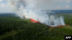 This July 24, 2023, handout image released by the British Columbia Wildfire Service, shows a fire fighting aircraft battling the Townsend Creek wildfire, soth of Baker Creek, British Columbia, Canadfa. (AFP PHOTO/BC Wildfire Service/Handout)