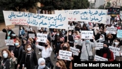 Mothers and activists carry banners and placards as they take part in a march to protest against the political and economic situation, ahead of Mother's Day in Beirut, Lebanon March 20, 2021. (Reuters/Emilie Madi)