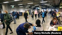 A person receives a dose of the Pfizer BioNTech COVID-19 vaccine at a mass vaccination center for those aged 18 and over at the Tottenham Hotspur Stadium, amid the coronavirus disease (COVID-19) pandemic, in London, Britain, June 20, 2021.
