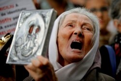 ROMANIA -- A woman shouts holding a religious icon during a protest against the use of face masks and the protection measures against the COVID-19 infections in Bucharest, October 10, 2020.