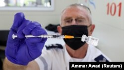 FILE PHOTO: A health worker prepares a vaccination against the coronavirus disease (COVID-19) at a mobile vaccination centre, as Israel continues to fight against the spread of the Delta variant, in Tel Aviv, Israel July 6, 2021.
