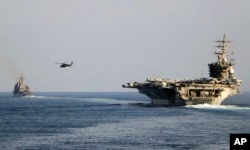 The aircraft carrier USS Dwight D. Eisenhower and other warships cross the Strait of Hormuz into the Persian Gulf on November 26, 2023, as part of a wider American deployment in the Middle East amid the Israel-Hamas war. (Ruskin Naval/U.S. Navy/via AP)