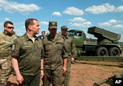 Deputy head of Russia's Security Council and chairman of the United Russia party, Dmitry Medvedev, second left, visits Totsk military garrison in the Orenburg region on August 5, 2022. (Ekaterina Shtukina/Sputnik,/via AP)