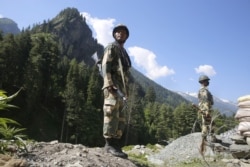 Indian paramilitary soldiers stand guard at a check post along a highway leading to Ladakh, at Gagangeer some 81 kilometers from Srinagar, India, the summer capital of Indian Kashmir.