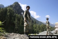 Indian paramilitary soldiers stand guard at a check post along a highway leading to Ladakh, at Gagangeer some 81 kilometers from Srinagar, India, the summer capital of Indian Kashmir.