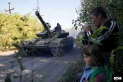 Ukraine -- Local people look at pro-Russian separatist tanks withdrawing them from the frontline in the Luhansk region, October 3, 2015