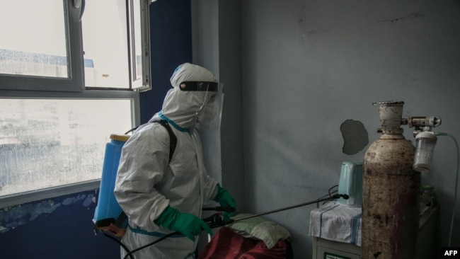 MADAGASCAR – A health worker disinfects a room at the Andohatapenaka University Hospital. Source: AFP