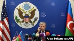 Azerbaijan -- U.S. National security adviser John Bolton adjusts his glasses while speaking to the media after his talks with Azerbaijan's President Ilham Aliyev in Baku, Azerbaijan, Wednesday, Oct. 24, 2018