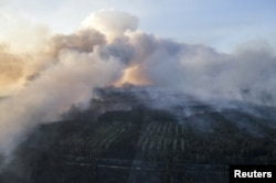An aerial view through a window of a helicopter shows smoke from forest fires in northern Ukraine, April 28, 2015. Emergency services were battling to prevent Ukraine's largest forest fire since 1992 from spreading towards Chernobyl