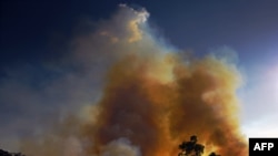 PARA – Smoke rises from an illegally lit fire in Amazon rainforest reserve, south of Novo Progresso in Para state, Brazil, on August 15, 2020. (Photo by CARL DE SOUZA / AFP).