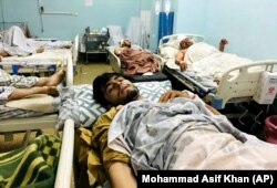 Wounded Afghans at a hospital after deadly suicide bombings outside the airport in Kabul killed at least 95 Afghans and 13 U.S. troops on August 26, 2021. (Mohammad Asif Khan/AP)