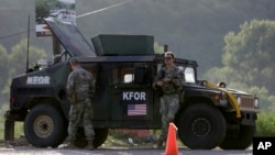 U.S. soldiers serving in NATO-led peacekeeping force KFOR, guard a checkpoint on the road near the village of Leposavic, northern Kosovo, on Aug. 18, 2022. (AP Photo/Bojan Slavkovic, File)