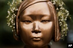 A statue commemorating so-called "comfort women," a euphemism given by Japan to the women and girls enslaved for sex by the Japanese army during World War II, in a residential area in central Berlin, Germany on October 9, 2020. Markus Schreiber/AP
