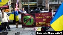 U.S. – Ukrainian-American demonstrators protest outside of the Russian TV network, RT, for misleading the public on the conflict between Ukraine and Russia, in Washington, April 11, 2014.