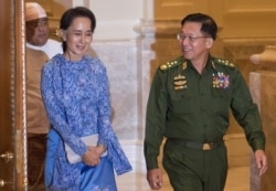 In this photo taken March 30, 2016, Myanmar's Aung San Suu Kyi and military chief Senior General Min Aung Hlaing arrive for the handover ceremony at the presidential palace in Naypyidaw.