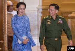 In this photo taken March 30, 2016, Myanmar's Aung San Suu Kyi and military chief Senior General Min Aung Hlaing arrive for the handover ceremony at the presidential palace in Naypyidaw.
