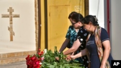 Women lay flowers at a makeshift memorial in front of the Holy Assumption Cathedral after an attack by Islamic militants in Makhachkala, Republic of Dagestan, Russia, on June 24, 2024. (AP)
