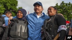 Nicaraguan police take a photo with President Daniel Ortega (center) after weeks of unrest in Masaya, Nicaragua, on July 13, 2018. (AP Foto/Cristobal Venegas)