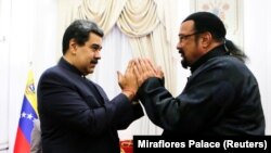 Venezuelan President Nicolas Maduro (L) and actor Steven Seagal gesture after Maduro received a samurai sword as a gift from Seagal, who was visiting Venezuela as a representative of Russia, in Caracas, May 4, 2021. (Reuters)