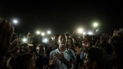 A young man, illuminated by mobile phones, reciting protest poetry while demonstrators chant slogans calling for civilian rule, during a blackout in Khartoum, Sudan June 19, 2019. (Reuters)