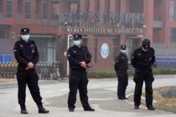 Security personnel gather near the entrance of the Wuhan Institute of Virology during a visit by the World Health Organization team, February 3, 2021. (Ng Han Guan/AP)