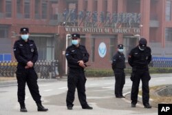 Security personnel gather near the entrance of the Wuhan Institute of Virology during a visit by the World Health Organization team, February 3, 2021. (Ng Han Guan/AP)