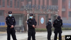 Security personnel gather near the entrance of the Wuhan Institute of Virology during a visit by the World Health Organization team in Wuhan on February 3, 2021. (Ng Han Guan/AP)